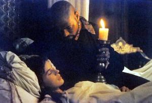 Othello with a candle looking at the sleeping Desdemona